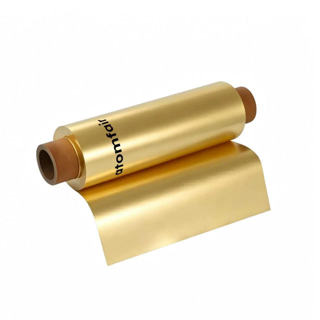 ATOMFAIR® a roll of shiny metallic golden brass foil on a brown core with a smooth yellow-gold sheet extending out.
