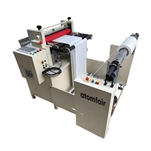 ATOMFAIR® automatic die cutting machine with a cream chassis, a side touchscreen panel, and a white web material winding through rollers.