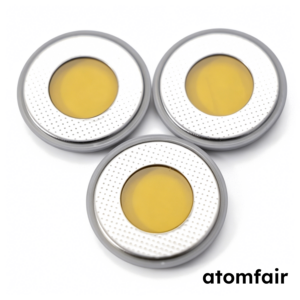 ATOMFAIR® three Kapton window coin cell case sets with dual sided translucent yellow windows and perforated metallic rims on a white background.