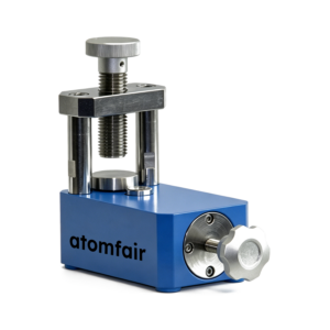 ATOMFAIR® blue micro powder tablet press with a top adjustable screw and silver front knob on a white background.