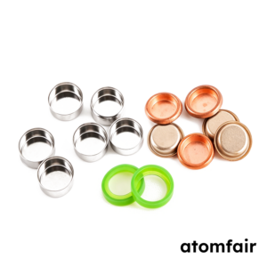 ATOMFAIR® nickel coated coin cell case sets displaying silver cups copper colored parts and bright green sealing rings on a white background.