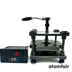ATOMFAIR® metal pouch cell cycle test fixture with a top mechanical lever wrench connected to a digital controller on a white background.