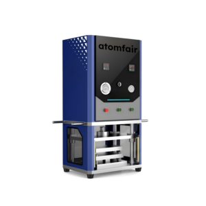 ATOMFAIR® film forming machine with a blue upper chassis, black control interface featuring dual gauges, and an open lower press chamber.