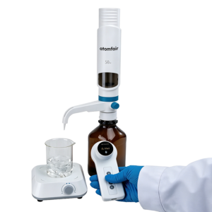 An operator holding the control module of an ATOMFAIR® dTitre-S electronic titrator during a laboratory titration workflow.